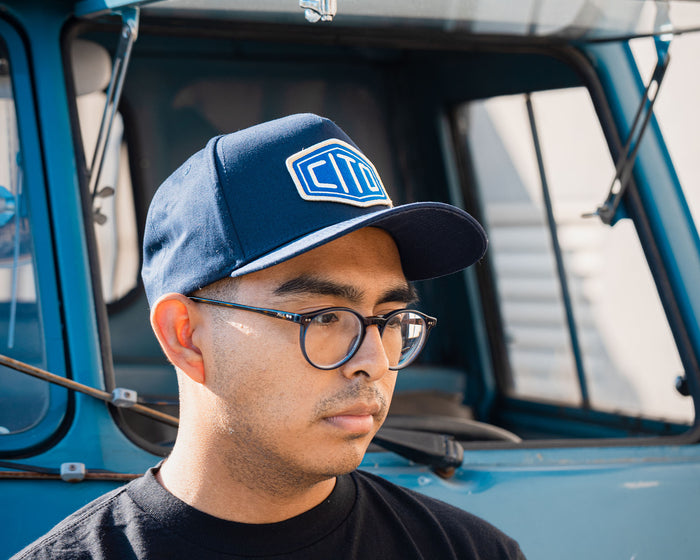 man wearing - blue suavecito hat with white embroidered text and blue background "cito"