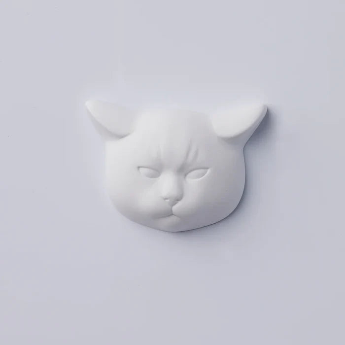 White cat-face decorative object with pointed ears and sculpted feline features, photographed against a clean white background in a minimalist product presentation.