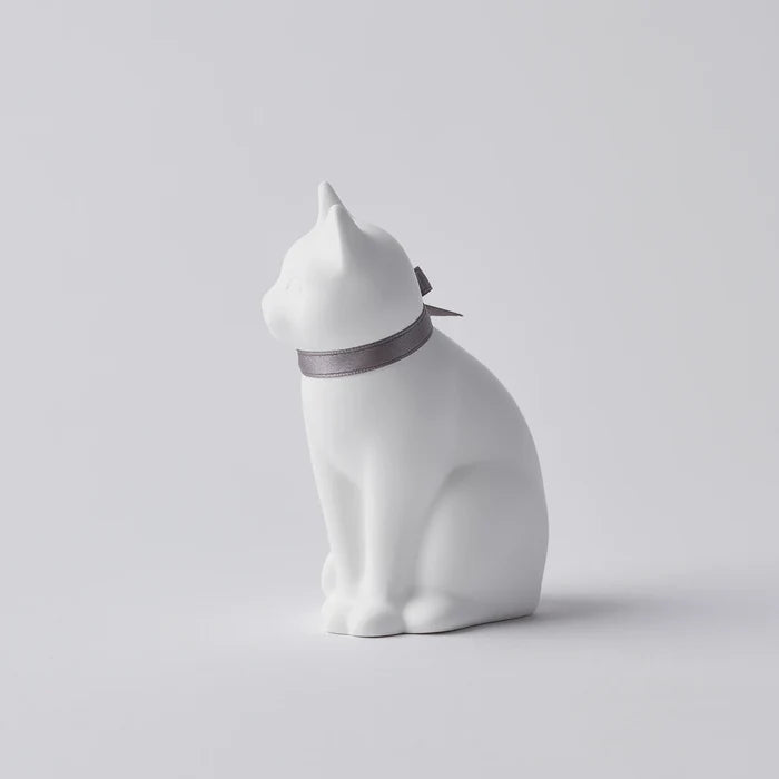 Side view of a white cat-shaped aroma ornament with a gray ribbon collar, displayed on a clean white background in a minimalist home decor product presentation.