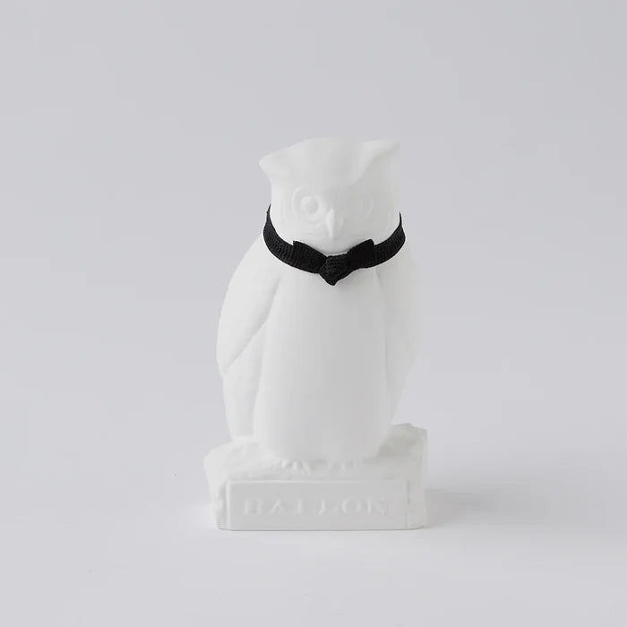 A white oil diffuser in the shape of an owl with a black collar.