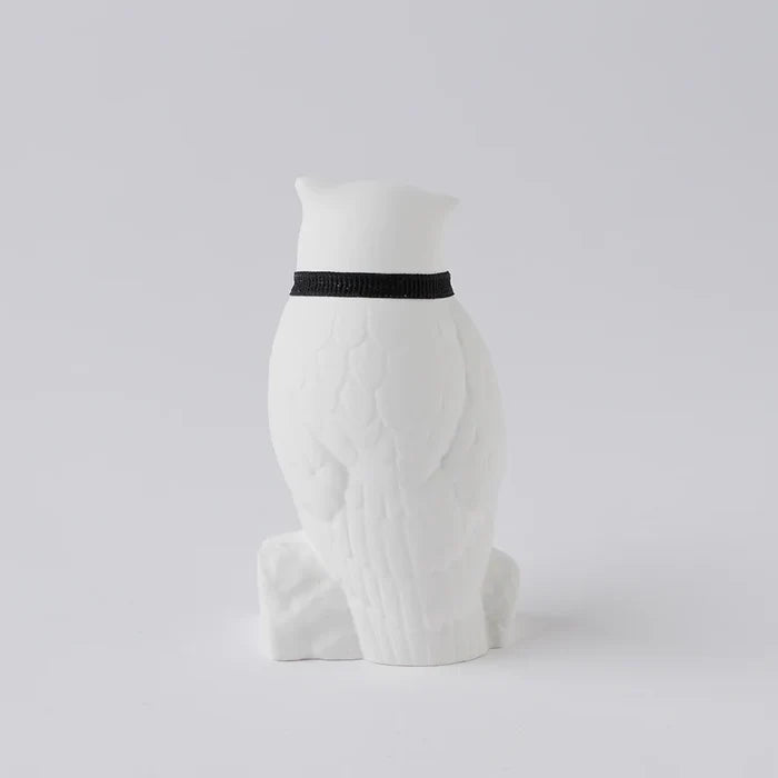 Rear view of a white owl-shaped aroma ornament with sculpted feather details and a black ribbon collar, displayed on a clean white background in a minimalist home decor product presentation.