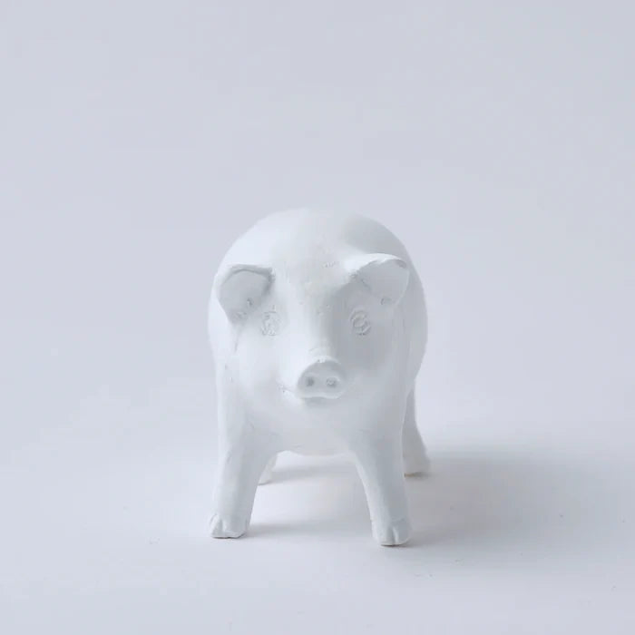 A white oil diffuser in the shape of a pig standing on a plain background.