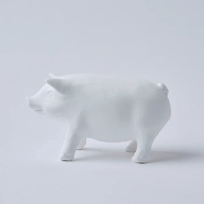 White pig-shaped decorative object with a minimalist sculpted form, shown in side profile against a clean white background in a simple product presentation.