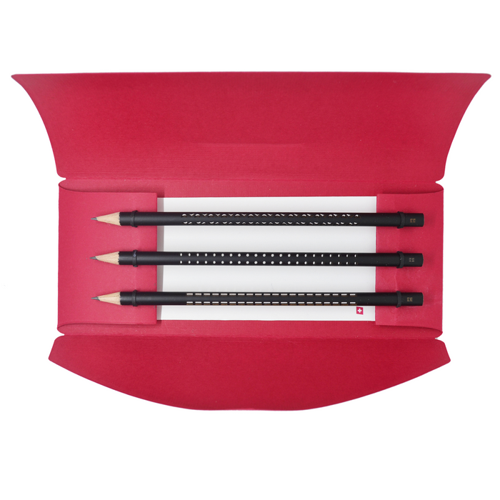 Set of three minimalist black designer pencils with patterned grip designs displayed in an elegant red gift box, modern premium stationery set for writing and drawing.