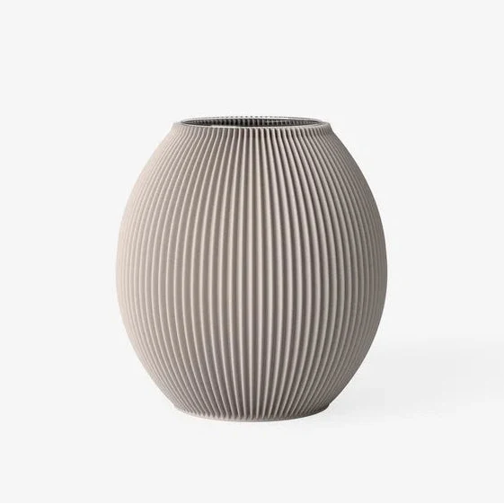 A ribbed ceramic vase in a warm taupe-beige color, featuring vertical fluted ridges and a rounded, bulbous shape, set against a plain white background.