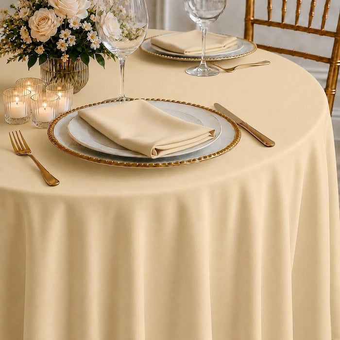 Beige polyester round tablecloth on a decorated dining table.