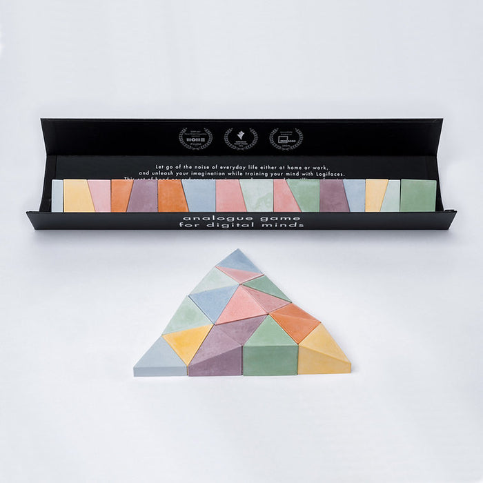 Logifaces, a geometric puzzle made of concrete triangular prisms, arranged in various configurations to form a continuous surface. The minimalist design encourages creative problem-solving and spatial thinking