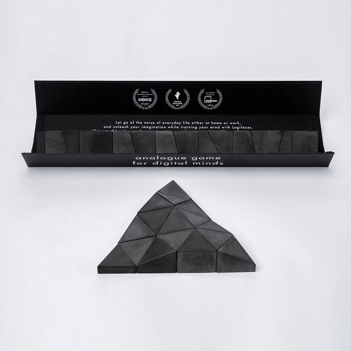 Logifaces, a geometric puzzle made of concrete triangular prisms, arranged in various configurations to form a continuous surface. The minimalist design encourages creative problem-solving and spatial thinking