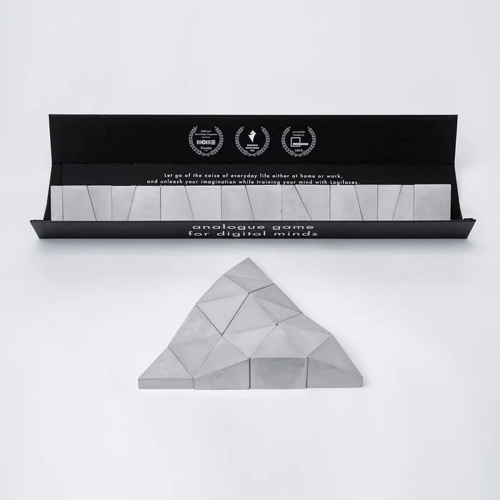 Logifaces, a geometric puzzle made of concrete triangular prisms, arranged in various configurations to form a continuous surface. The minimalist design encourages creative problem-solving and spatial thinking