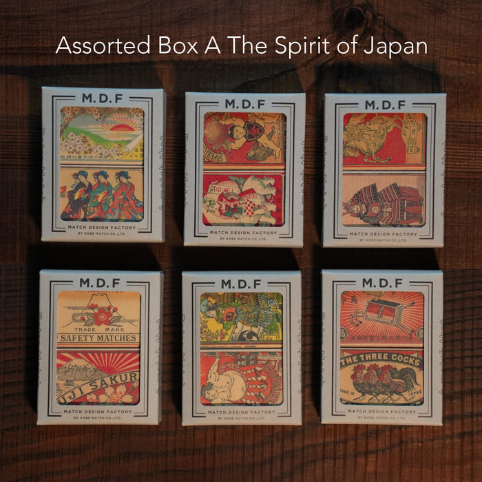 Six vintage-style Japanese matchboxes arranged in two rows of three on a wooden surface. Each box is labeled “M.D.F. Match Design Factory” and features colorful traditional illustrations such as geisha, samurai, Mount Fuji, animals, and retro motifs. White text at the top reads, “Assorted Box A The Spirit of Japan.”