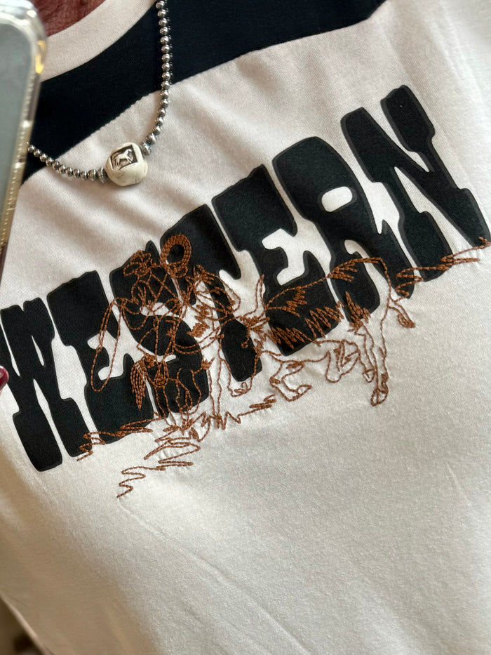 White long sleeve shirt detail with western lettering and cowboy graphic