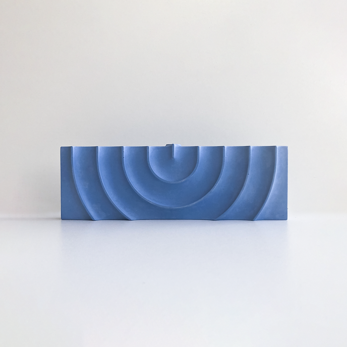 Logifaces, a geometric puzzle made of concrete triangular prisms, arranged in various configurations to form a continuous surface. The minimalist design encourages creative problem-solving and spatial thinking