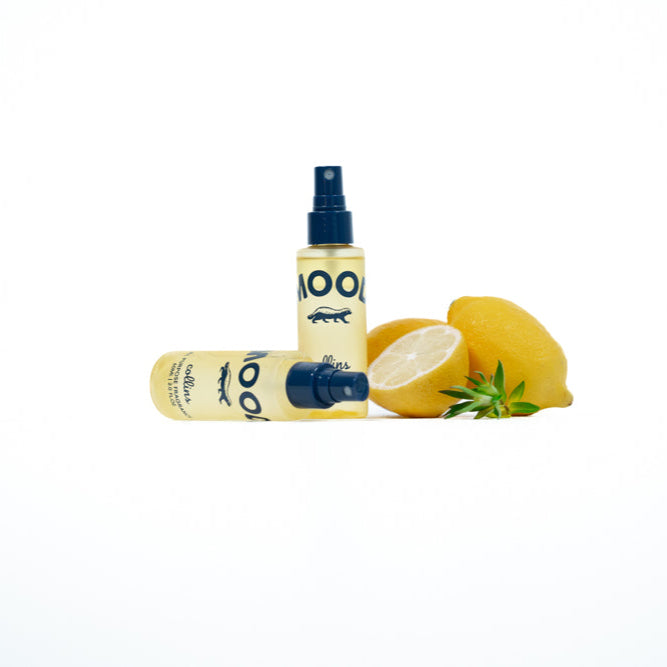 Two bottles of a product with a lemon on a white background