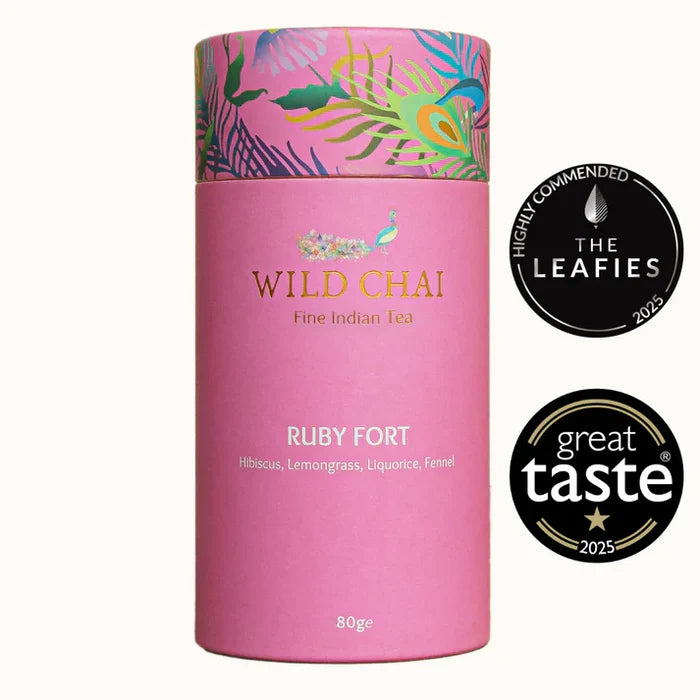 Pink canister of Wild Chai Ruby Fort tea with decorative lid on a white background