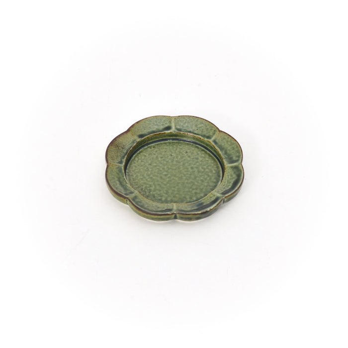 A single small ceramic dish on a white background with a scalloped edge and earthy green glaze, showing subtle texture and a slightly raised rim.