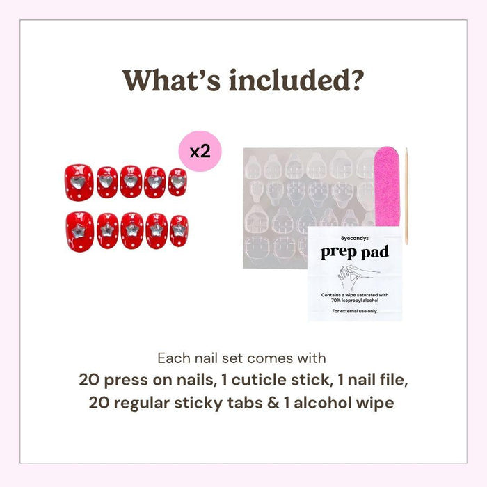 Image shows EyeCandys Spot the Difference Press-On Nails (2 sets of 20 red heart designs), sticky tabs, pink nail file, and alcohol prep pad—everything for a salon-style manicure at home. Text lists included items.
