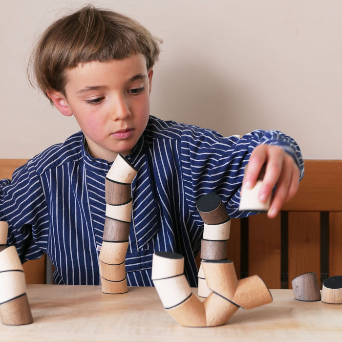 Child playing with wooden building blocks at a table