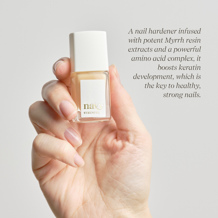 Close up o hand holding Strength bottle describing a nail hardener infused with Myrrh resin extracts and amino acid complex