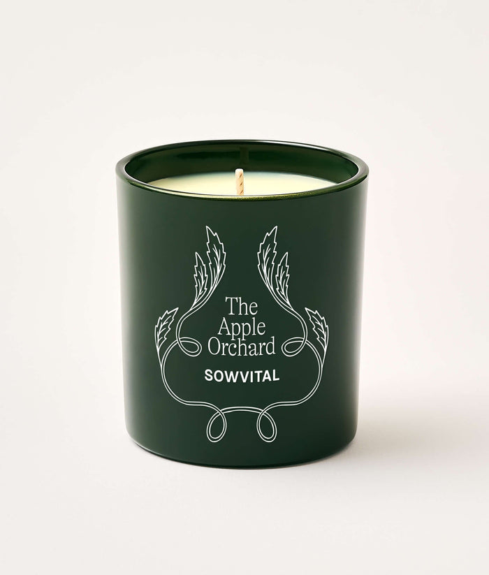Green candle with 'The Apple Orchard' branding on a white background