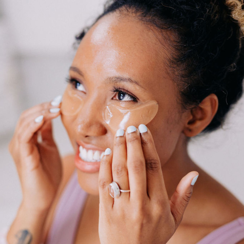 A black woman shown wearing Frownies cactus collagen under eye gels
