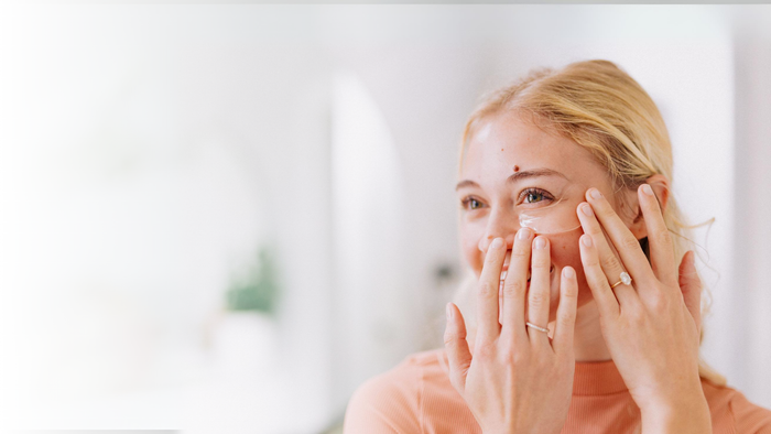 blonde woman applying frownies under eye gels with cactus collagen on face