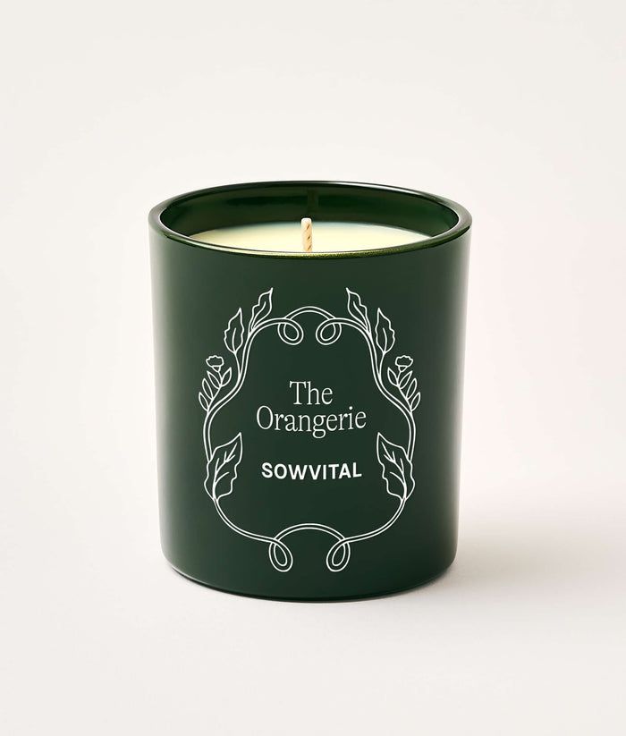 Green candle with 'The Orangerie' and 'SOWVITAL' text on a white background