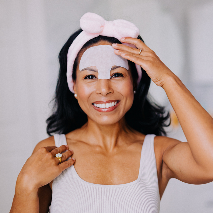 Woman wearing a pink headband and Frownies Serum patch