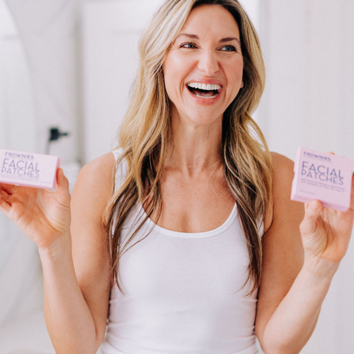 Woman holding two boxes of Frownies Facial Patches