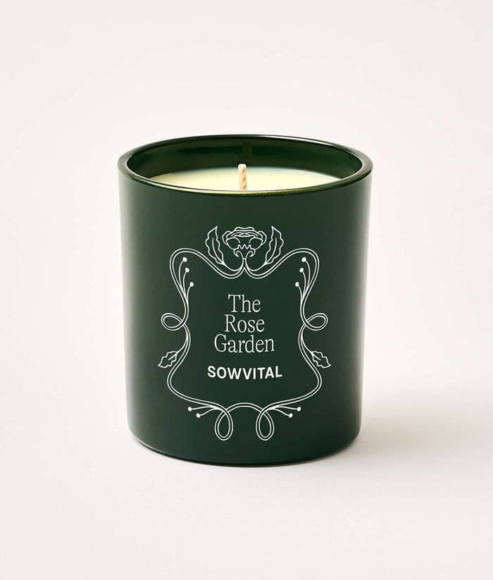 Green candle with 'The Rose Garden' branding on a white background
