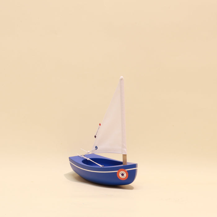 Model sailboat on a beige background