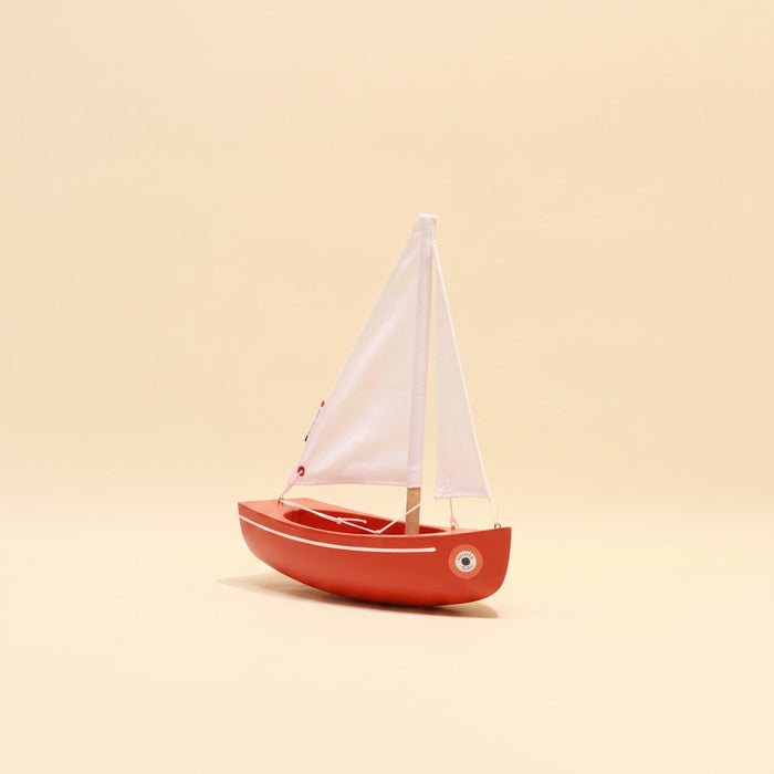 Model sailboat on a beige background