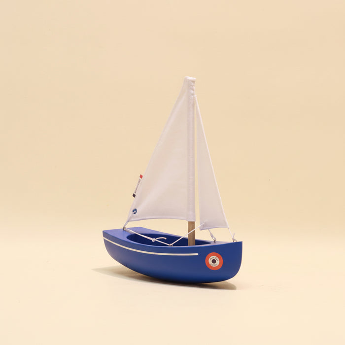 Model sailboat on a beige background