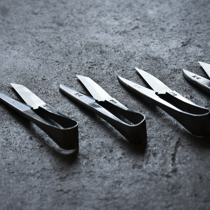 Set of black-handled scissors on a dark textured surface