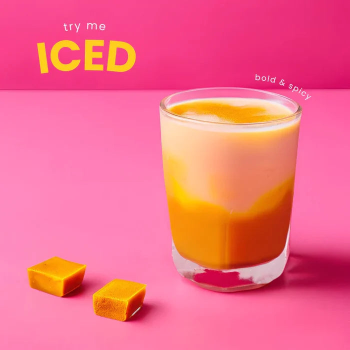 Glass of iced drink with ice cubes on a pink background, featuring text 'try me ICED' and 'bold & spicy'.