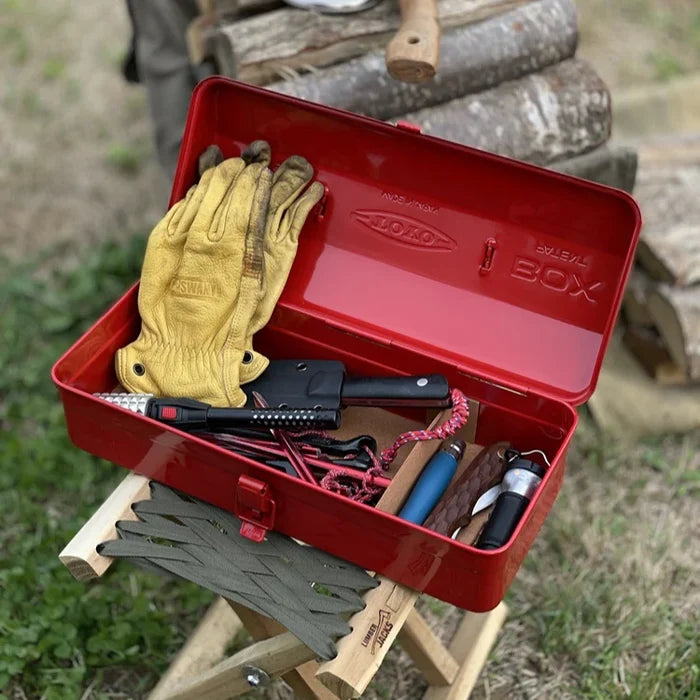 Red toolbox with tools and gloves on a wooden stand outdoors
