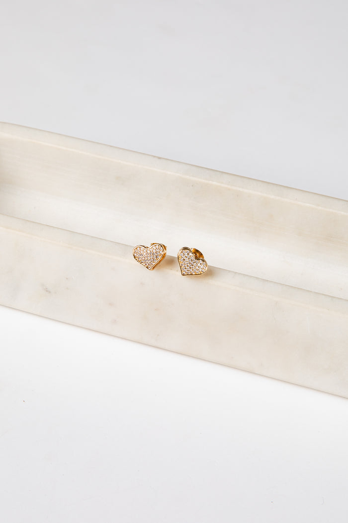 Gold heart-shaped earrings on a white satin ribbon